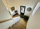 Bright and airy staircase landing featuring a bench, artwork, and a glimpse of the front door at 1231 Marlowe Ave, Indianapolis, IN 46202