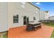 A wooden deck provides a nice outdoor space complete with a table and chairs, sliding door entry, and green backyard at 12422 River Valley Dr, Fishers, IN 46037