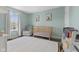 Bedroom with mint walls, wood floors, a crib, glider chair, white curtains, and a colorful rug at 12422 River Valley Dr, Fishers, IN 46037