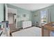 Bright Bedroom featuring mint walls, wood floors, a white dresser, and a view to another room through an open doorway at 12422 River Valley Dr, Fishers, IN 46037