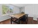 Bright dining area features wood floors, a wooden table, modern black chairs, and a large window with natural light at 12422 River Valley Dr, Fishers, IN 46037