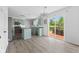 Spacious kitchen featuring sage cabinets, stainless steel appliances, wood-look flooring, and backyard access at 12422 River Valley Dr, Fishers, IN 46037