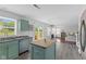 Open kitchen with sage cabinets, stainless steel appliances, wood-look flooring, and easy access to the backyard at 12422 River Valley Dr, Fishers, IN 46037