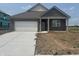Charming single-story brick home featuring a pristine white garage door and manicured lawn on a sunny day at 1266 Foxtail Ln, Greenwood, IN 46143