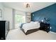 Bedroom with accent wall, floating shelves, large windows, and a full-size bed at 14130 Autumn Woods Dr, Carmel, IN 46074