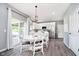 Bright dining area with a modern chandelier, white table, and sliding glass doors to the outdoor patio at 14130 Autumn Woods Dr, Carmel, IN 46074