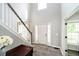 Welcoming foyer with hardwood floors, staircase, and ample natural light from a large window at 14130 Autumn Woods Dr, Carmel, IN 46074