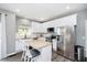 Modern kitchen with white cabinets, stainless steel appliances, granite countertops, and a breakfast bar at 14130 Autumn Woods Dr, Carmel, IN 46074