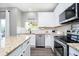 Updated kitchen with white cabinetry, granite countertops, stainless steel appliances, and modern fixtures at 14130 Autumn Woods Dr, Carmel, IN 46074