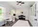 Bright office featuring a ceiling fan, large window, built-in shelves, white cabinets, a white desk, and an electric piano at 14130 Autumn Woods Dr, Carmel, IN 46074