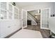Office with built-in shelves, white cabinets, and a view into the foyer, dining room, and staircase at 14130 Autumn Woods Dr, Carmel, IN 46074