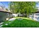 Landscaped backyard with green grass, a stone fire pit, and a detached garage at 1426 N Euclid Ave, Indianapolis, IN 46201