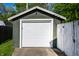 Detached garage featuring green siding, white garage door, and a privacy fence at 1426 N Euclid Ave, Indianapolis, IN 46201