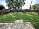 Large backyard includes green grass, stone patio, a fire pit and playground equipment at 1570 S Harriet St, Martinsville, IN 46151