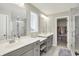 Modern bathroom boasts dual sinks, sleek gray cabinetry, and a glass-enclosed shower with marble tile at 15717 Hush Hickory, Westfield, IN 46074