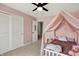 Pink bedroom featuring a canopy bed, carpet, and closet at 15717 Hush Hickory, Westfield, IN 46074