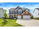 Inviting two-story home featuring a brick and siding facade, attached two-car garage, and well-manicured lawn at 15717 Hush Hickory, Westfield, IN 46074