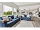Open-concept living room featuring a comfortable seating area, large windows, and a view of the modern kitchen at 15717 Hush Hickory, Westfield, IN 46074