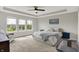 Bright main bedroom with large windows, tray ceiling, and a relaxing sitting area with neighborhood views at 15717 Hush Hickory, Westfield, IN 46074