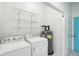 Bright laundry room with white washer, dryer, shelving, and energy-efficient water heater at 1804 Spann Ave, Indianapolis, IN 46203