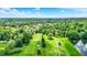 Expansive aerial shot showcasing the golf course, pond, and surrounding wooded landscape at 1860 Red Fox E Ct, Martinsville, IN 46151
