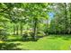 Lush backyard with mature trees and manicured lawn, offering a serene and private outdoor retreat at 1860 Red Fox E Ct, Martinsville, IN 46151