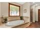 Relaxing bathroom with soaking tub, decorative tile, and natural light at 1860 Red Fox E Ct, Martinsville, IN 46151