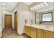 Bright bathroom with double vanity, natural wood cabinets, and a large window with natural light at 1860 Red Fox E Ct, Martinsville, IN 46151