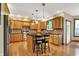 Open kitchen with stainless steel appliances, wood cabinets, large island with barstool seating and hardwood floors at 1860 Red Fox E Ct, Martinsville, IN 46151