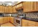 Well-appointed kitchen boasting stainless steel appliances, granite countertops, and mosaic tile backsplash at 1860 Red Fox E Ct, Martinsville, IN 46151