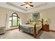 Main bedroom featuring a tray ceiling, large arched window, and comfortable furnishings for a restful retreat at 1860 Red Fox E Ct, Martinsville, IN 46151