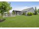 Large backyard with a covered grilling station and dining area, plus a charming fire pit and seating arrangement at 18630 Goldwater Rd, Westfield, IN 46062