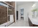 Modern bathroom featuring a glass shower with tile surround, double vanity, and view to the main bedroom at 18630 Goldwater Rd, Westfield, IN 46062