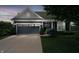 Charming single-story home with a two-car garage and a well-manicured lawn at dusk at 18630 Goldwater Rd, Westfield, IN 46062