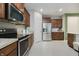 Modern kitchen featuring stainless appliances, wood cabinets, granite countertops, and tile flooring at 18630 Goldwater Rd, Westfield, IN 46062
