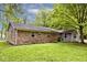 A brick house features a grassy backyard bordered by trees and greenery, providing a serene outdoor space at 19446 Ethan Allen Ln, Westfield, IN 46074