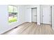 Light-filled bedroom featuring a window and closet with shelving, complemented by wood-look flooring at 19446 Ethan Allen Ln, Westfield, IN 46074