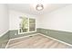 Bright living room featuring wood-look flooring, and ample natural light from a large window overlooking the front yard at 19446 Ethan Allen Ln, Westfield, IN 46074
