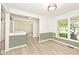 Open-concept living room with large window, light gray walls, white trim, and wood-look flooring at 19446 Ethan Allen Ln, Westfield, IN 46074