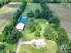 Expansive property featuring a brick home with metal roof, a pond, a barn, and surrounding fields and trees at 19702 Centennial Rd, Sheridan, IN 46069