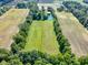 Panoramic aerial shot showcasing a property surrounded by farmland, trees, and featuring a charming pond at 19702 Centennial Rd, Sheridan, IN 46069