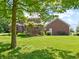 Backyard with a lush lawn, mature trees, and a charming pergola, creating a serene outdoor setting at 19702 Centennial Rd, Sheridan, IN 46069