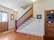 Inviting foyer features hardwood floors, staircase with wood banister and trim, and decorative stained glass door at 19702 Centennial Rd, Sheridan, IN 46069