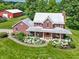 Beautiful two-story brick home featuring a metal roof, covered porch, and meticulously landscaped front yard at 19702 Centennial Rd, Sheridan, IN 46069