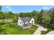 Aerial view of a modern home with beautiful landscaping, a long driveway, and mature trees at 20400 Chatham Hills Blvd, Westfield, IN 46074