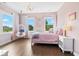 Bright pink bedroom featuring a hanging egg chair, a white bed, and windows for natural light at 20400 Chatham Hills Blvd, Westfield, IN 46074