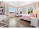 Light-filled bedroom with pale pink walls, hardwood floors, and a hanging chair near windows providing natural light at 20400 Chatham Hills Blvd, Westfield, IN 46074