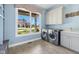 Bright laundry area with modern appliances, a window showcasing the yard, and plenty of storage at 20400 Chatham Hills Blvd, Westfield, IN 46074