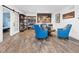 Inviting living room featuring wood-look floors, a custom bar area, and comfortable seating with bright blue accents at 20400 Chatham Hills Blvd, Westfield, IN 46074