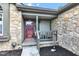 Inviting front porch with stone facade, seating area, and a decorative door at 206 Cranberry Dr, Greenfield, IN 46140